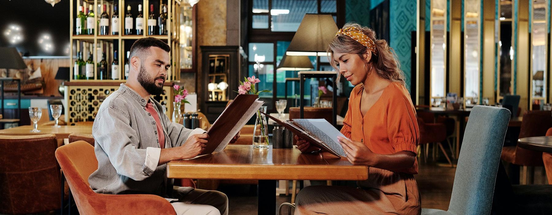 a man and a woman sitting at a table with a laptop